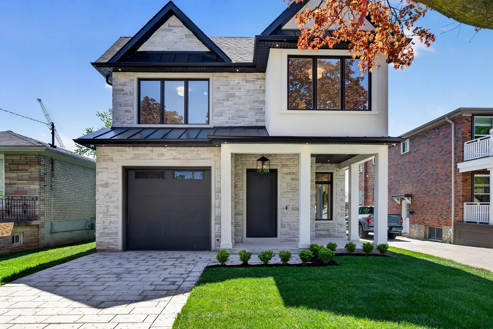 Modern two-storey home with a stone and stucco front, black trim and a covered front porch